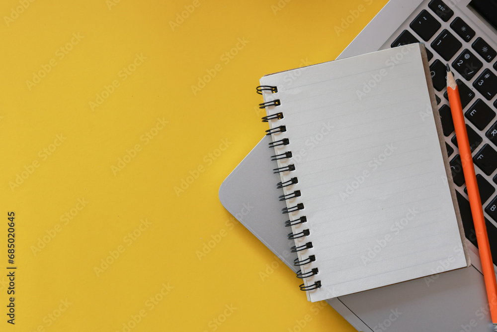 close up top view on white blank notebook with pencil and keyboard laptop on yellow background for reminder and note about plan , work and management schedule time concept close up top view on white blank notebook with pencil and keyboard laptop on yellow background for reminder and note about plan , work and management schedule time concept