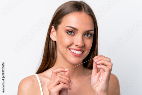 Young caucasian woman isolated on white background using dental floss with happy expression. Close up portrait