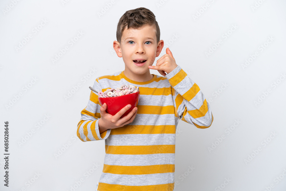 Little caucasian boy holding a cereal bowl isolated on white background making phone gesture. Call me back sign
