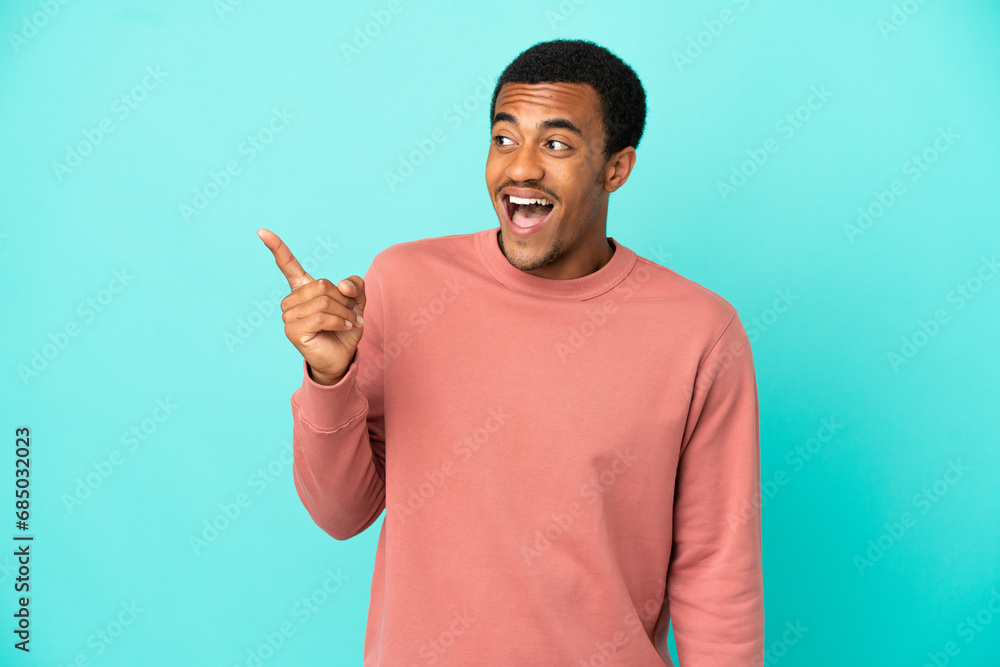 Fototapeta premium African American handsome man on isolated blue background intending to realizes the solution while lifting a finger up