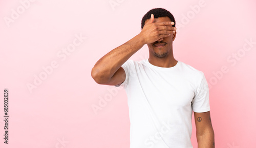 African American man on copyspace pink background covering eyes by hands. Do not want to see something photo