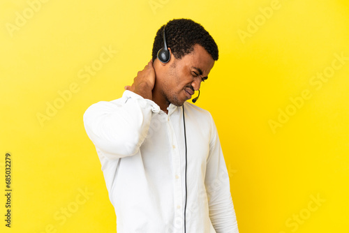 African American Telemarketer man working with a headset over isolated yellow background with neckache