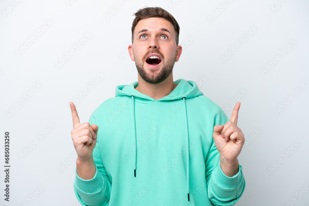 Young caucasian man isolated on white background surprised and pointing up Young caucasian man isolated on white background surprised and pointing up