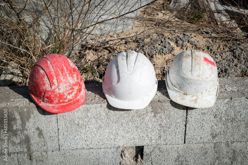 Capacetes de operários da construção civil em cima de um muro de blocos em construção photo