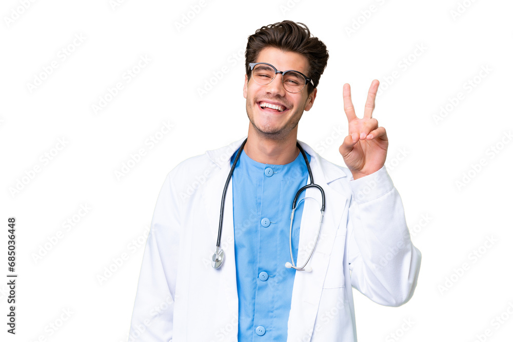 Young doctor man over isolated background smiling and showing victory sign Young doctor man over isolated background smiling and showing victory sign