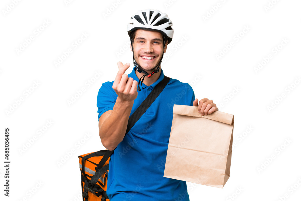 Young caucasian man taking a bag of takeaway food over isolated background making money gesture Young caucasian man taking a bag of takeaway food over isolated background making money gesture