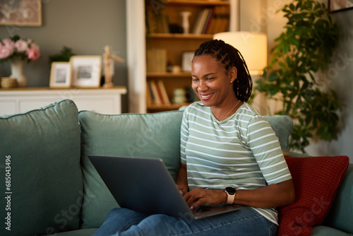 Happy african american woman with laptop at home