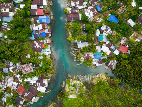 Houses and fishing boats along the Bogac Cold Spring in Surigao del Sur. Philippines. photo