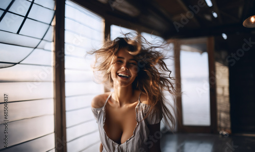 Candid shot of cheerful young woman with messy hair smiling wide photo