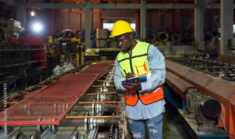 A factory worker is standing on a production line conveyor belt, probably checking or manipulating the manufacturing process. A factory worker is standing on a production line conveyor belt, probably checking or manipulating the manufacturing process.