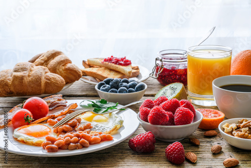 Breakfast buffet. Full english and continental. Large selection of brunch and breakfast food on the table with egg, bacon, toast, orange juice, croissant, coffee, fruits and nuts photo