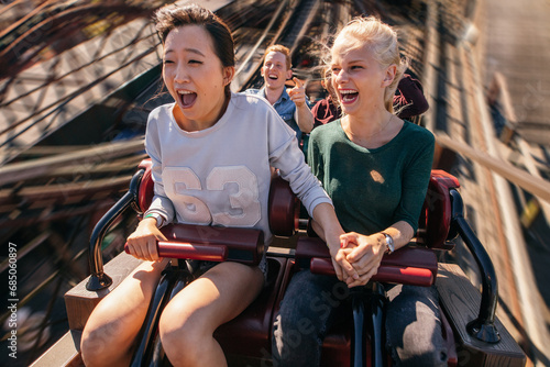 Happy young people riding a roller coaster © Jacob Lund