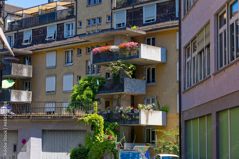 Naklejka premium Facade of residential building with beautiful decorated balcony on a hot sunny summer day at Swiss City of Zürich. Photo taken July 11th, 2023, Zurich, Switzerland.