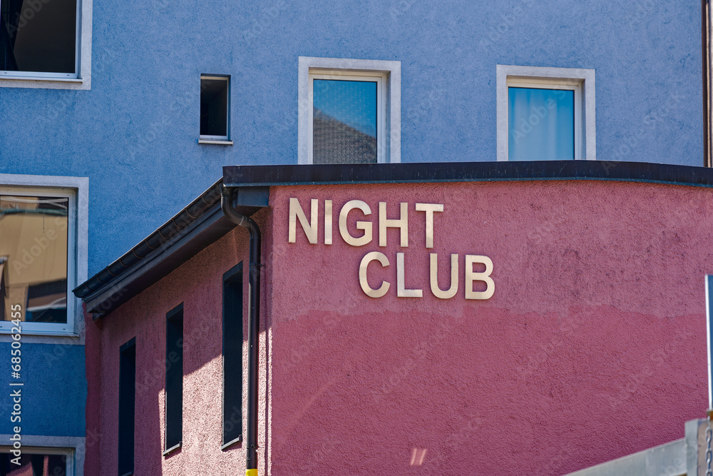 Obraz premium Night club with text Night Club fixed at red facade at Swiss City of Zürich on a hot sunny summer day. Photo taken July 11th, 2023, Zurich, Switzerland.