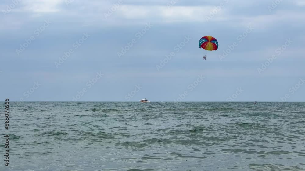 Parasailing: a boat with a marine parachute on the waves. The concept of a cloudy landscape, freedom and summer. Parachutists over the surface of the Black Sea against the sky on a summer day. 4K Parasailing: a boat with a marine parachute on the waves. The concept of a cloudy landscape, freedom and summer. Parachutists over the surface of the Black Sea against the sky on a summer day. 4K