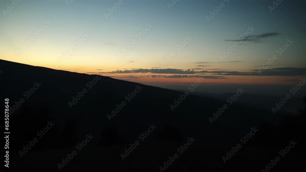 A sunset over a mountain. Nature's canvas ignites with a fiery afterglow, painting the sky with shades of evening as the sun sets behind a majestic mountain, creating a peaceful and breathtaking A sunset over a mountain. Nature's canvas ignites with a fiery afterglow, painting the sky with shades of evening as the sun sets behind a majestic mountain, creating a peaceful and breathtaking
