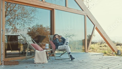 Wallpaper Mural A relaxed person sitting outside a modern cabin, enjoying nature Torontodigital.ca