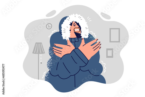 Frozen man in winter jacket is shivering from cold standing in unheated apartment and needs heater