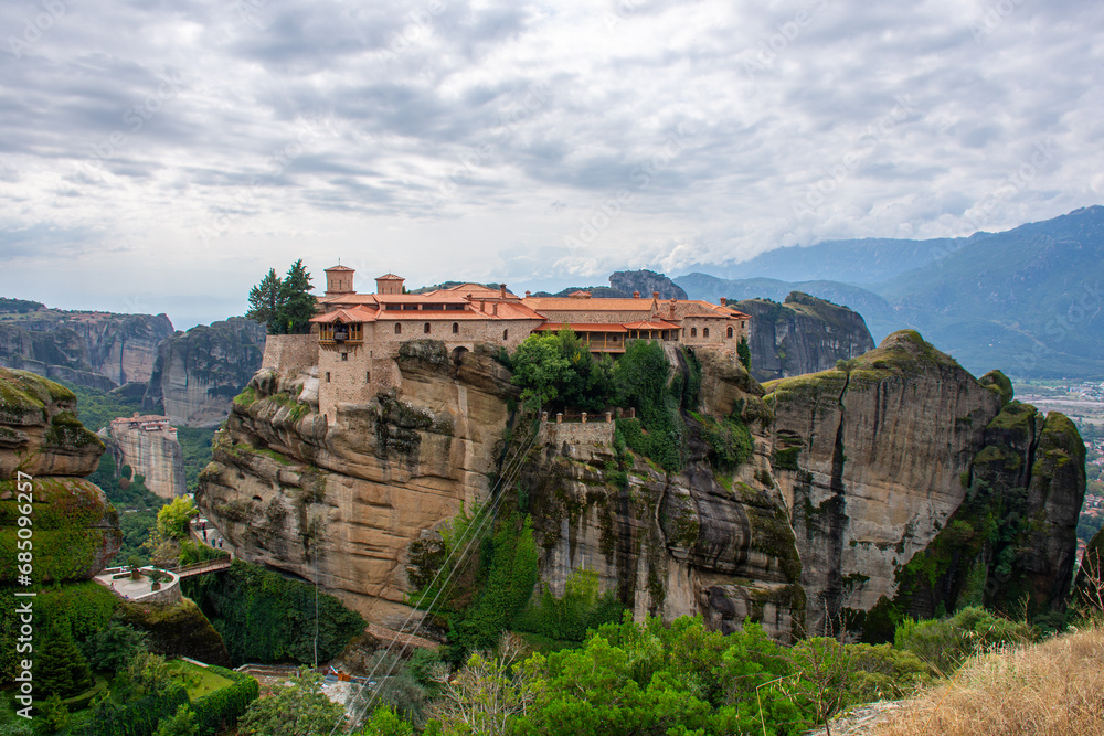 Holy Varlaam monastery on cliff in Meteora, Rousanou nunnery in the distance, Thessaly Greece. Greek destinations