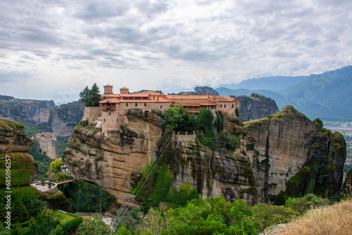 Holy Varlaam monastery on cliff in Meteora, Rousanou nunnery in the distance, Thessaly Greece. Greek destinations