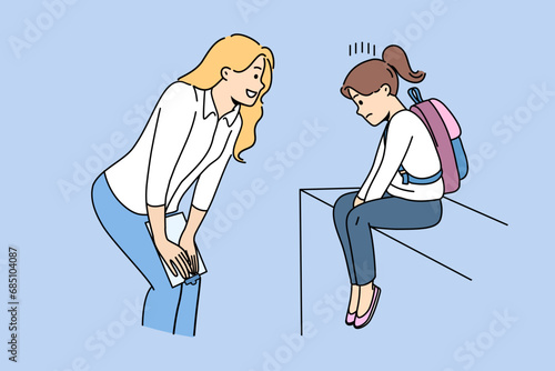 Woman teacher supports and motivates sad child who has problems with socialization and finding friends. Girl teacher consoles schoolgirl crying because of low grades or bullying from classmates photo