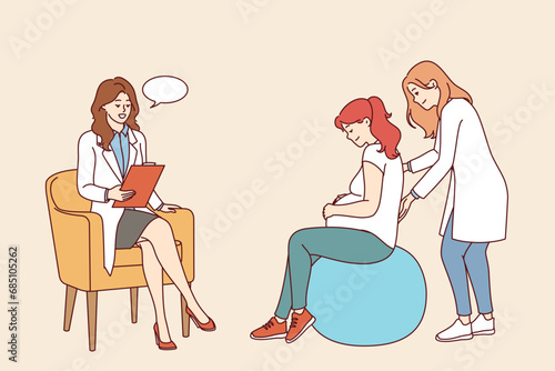 Pregnant woman undergoes courses for expectant mothers or is examined by obstetrician, sits on inflatable fitness ball. Pregnant girl listens to recommendations from medical workers