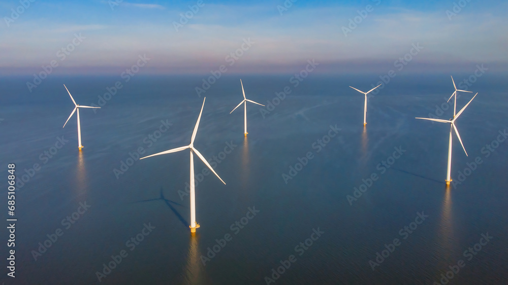 Windmill farm in the ocean Westermeerwind Park, windmills isolated at sea on a beautiful bright day in the Netherlands Flevoland Noordoostpolder. Huge windmill turbines at sea Windmill farm in the ocean Westermeerwind Park, windmills isolated at sea on a beautiful bright day in the Netherlands Flevoland Noordoostpolder. Huge windmill turbines at sea