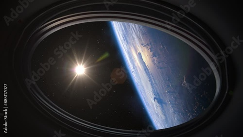 Spacecraft flies near the amazing blue planet Earth, view from the porthole. Planet Earth and Sun as viewed through the windows of a ISS. Elements of this video furnished by NASA.  photo