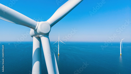 Windmill park in the ocean, drone aerial view of windmill turbines generating green energy electrically, windmills isolated at sea in the Netherlands.  photo