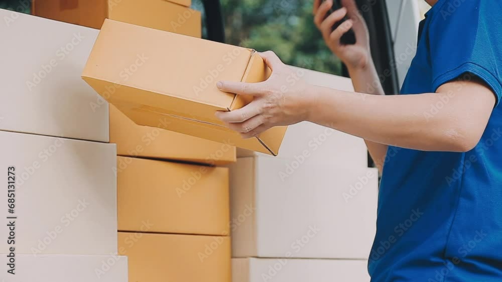 Fast and reliable service. Cheerful young delivery man giving a cardboard box to young woman while standing at the entrance of her apartment Fast and reliable service. Cheerful young delivery man giving a cardboard box to young woman while standing at the entrance of her apartment