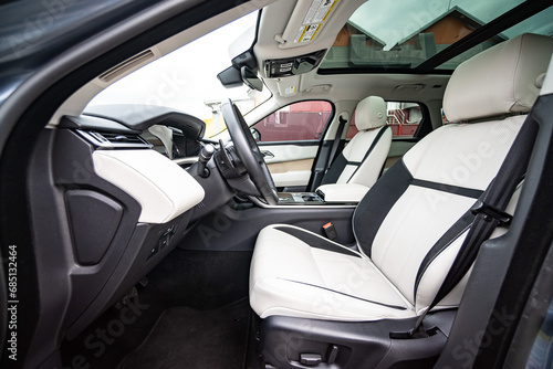 Modern luxury prestige car interior, dashboard, steering wheel. Orange red car interior. © Iryna