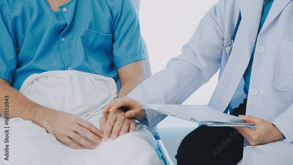 Senior doctor and young male patient who lie on the bed while checking pulse, consult and explain with nurse taking note and supporting in hospital wards. Senior doctor and young male patient who lie on the bed while checking pulse, consult and explain with nurse taking note and supporting in hospital wards.