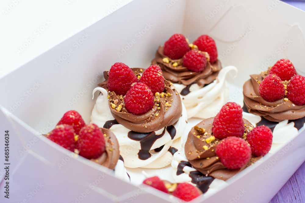 Mini cakes with whipped cream, chocolate, meringue and fresh raspberries. Confectionery poster for cafe or restaurant Mini cakes with whipped cream, chocolate, meringue and fresh raspberries. Confectionery poster for cafe or restaurant