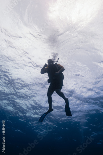 Scuba diver silhouette against water surface in Cancun, Mexico