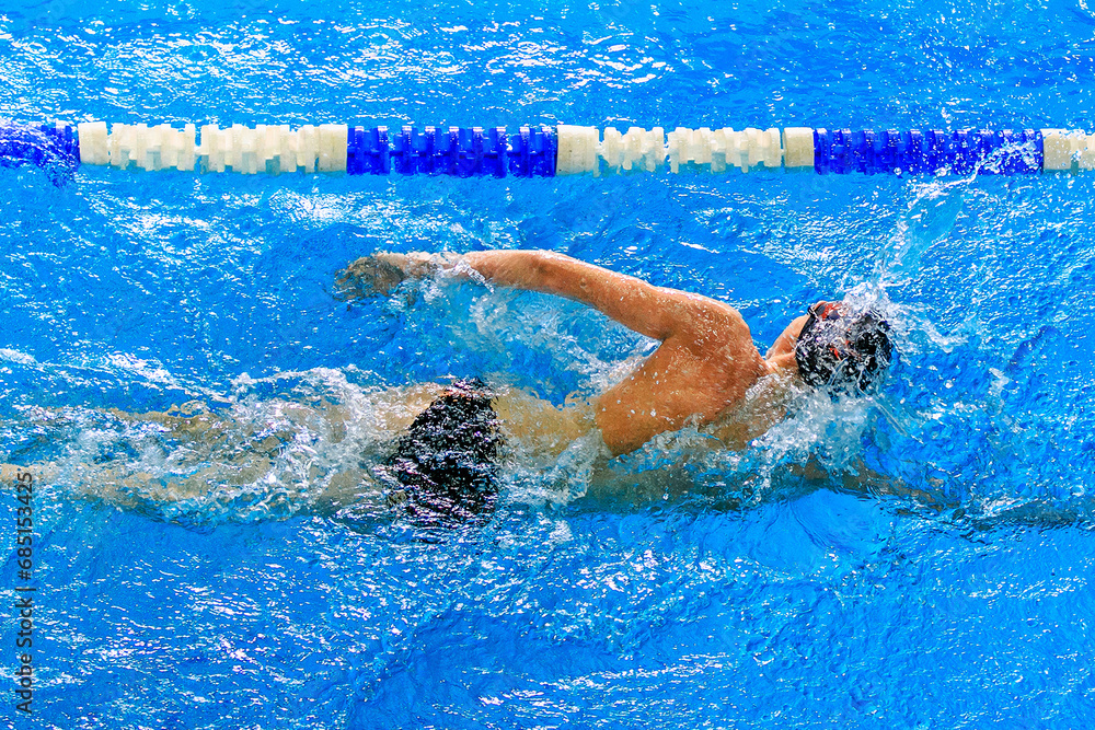 male swimmer swim front crawl in competition race, summer sports games