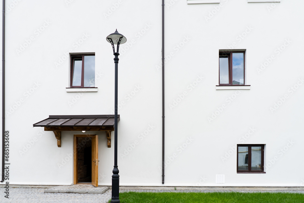 Modern building design house in concrete white with large windows and green lawn Modern building design house in concrete white with large windows and green lawn