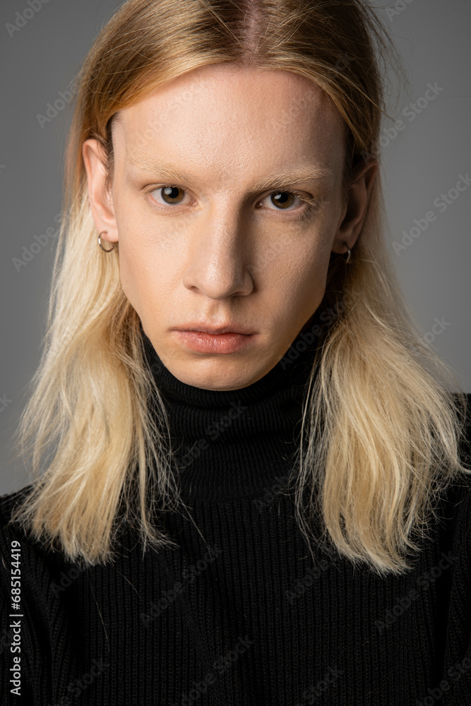vertical shot of good looking young non binary person in black turtleneck posing on gray backdrop vertical shot of good looking young non binary person in black turtleneck posing on gray backdrop