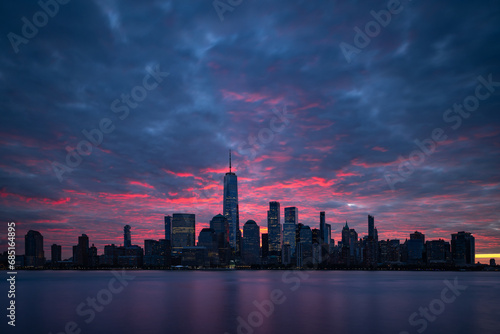 Night atmosphere with red pre-sunrise clouds above Lower Manhattan cityscape. New York panorama as captured from New Jersey.