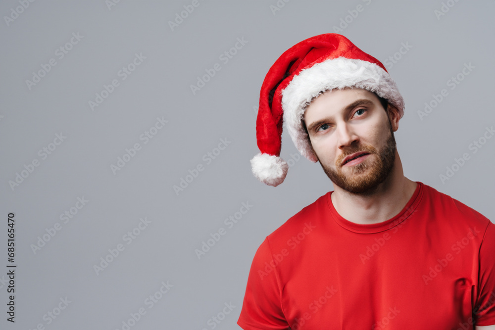 man in a festive hat. man in a red T-shirt and Christmas hat. holiday costume concept man in a festive hat. man in a red T-shirt and Christmas hat. holiday costume concept
