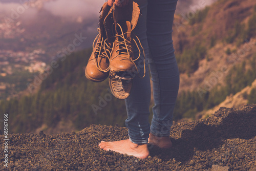 Concept back view of female people barefoot with broken shoes on hand admiring landscape panorama. Travel and poverty human. Freedom and nature background outdoors valley view. Copy space wanderlust
