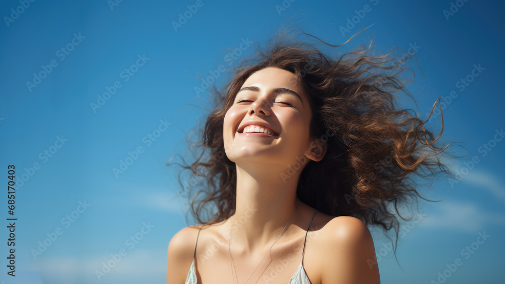 A Brunette woman breathes calmly looking up isolated on clear blue sky A Brunette woman breathes calmly looking up isolated on clear blue sky