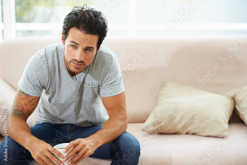 Depression, thinking and sad man on a sofa with stress, anxiety or broken heart at home. Fail, crisis or male person in living room overthinking, disaster or lonely, worried or disappointed in house photo