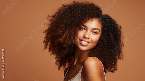 Hasselblad portrait photography of african american girl with clean healthy skin on beige background. Smiling dreamy beautiful black woman. Curly hair in afro style.