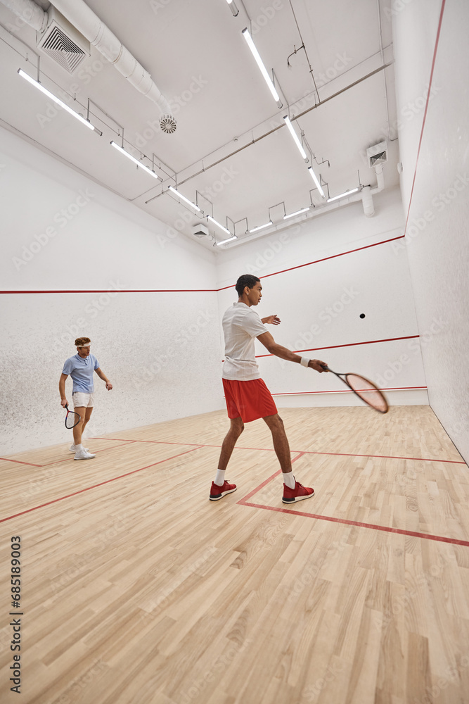 young interracial sportsmen playing squash together inside of indoor court, motivation and sport young interracial sportsmen playing squash together inside of indoor court, motivation and sport