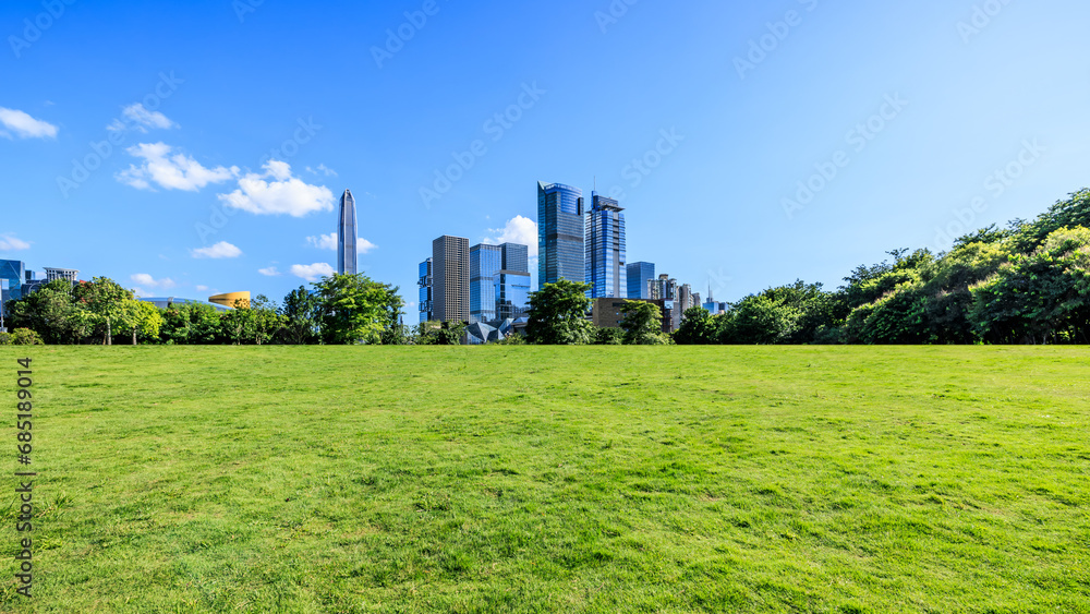 Fototapeta premium Green lawn and Shenzhen skyline with modern buildings under blue sky, Guangdong Province, China. Panoramic view.