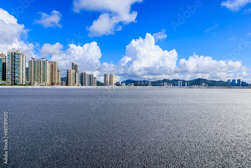 Asphalt road and skyline with residential area buildings scenery under the blue sky