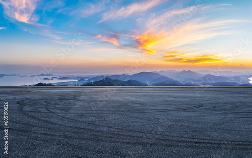 Asphalt road square and mountains with colorful sky clouds at sunset. High Angle view.