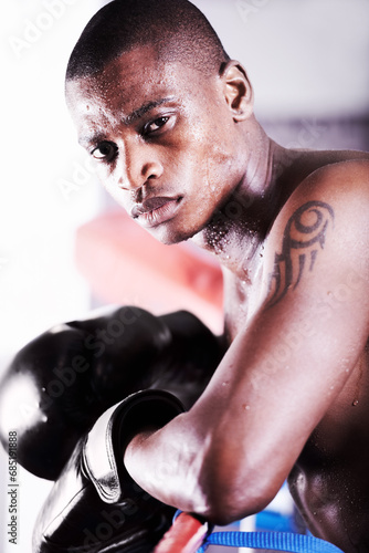 Boxing, gym and portrait of black man in ring with fitness, power and workout challenge at sports club. Strong body, face of athlete or boxer in gloves with sweat and confidence in competition fight.