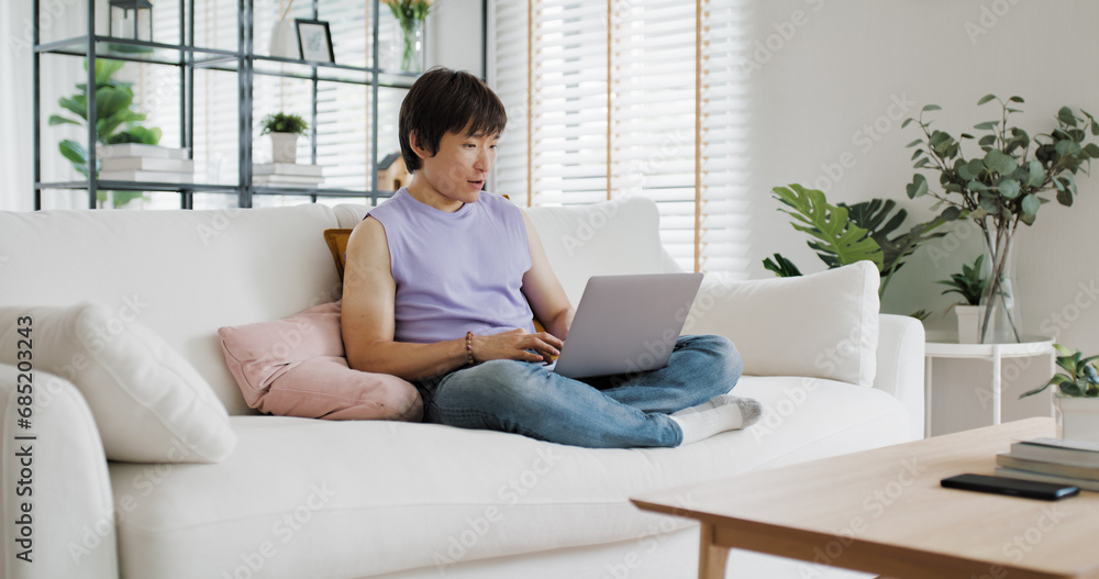 Gen Z queer man non-binary at home. Asia LGBT young guy adult people happy relax sitting at sofa use omni channel easy buy now pay later BNPL shop store. Reading online bank loan news on web page app. Gen Z queer man non-binary at home. Asia LGBT young guy adult people happy relax sitting at sofa use omni channel easy buy now pay later BNPL shop store. Reading online bank loan news on web page app.