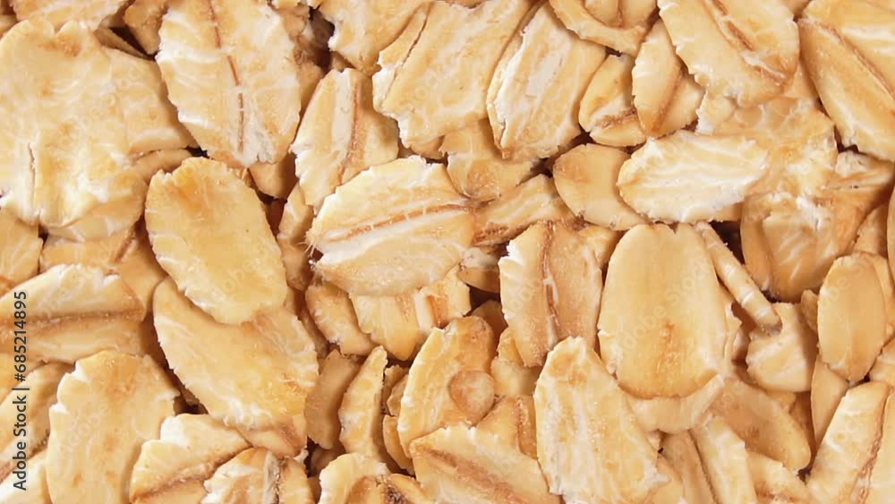 Oat Flakes Background Slowly Rotating Right - Top View, Close-Up. Scattered Dry Oat Flakes. Healthy Breakfast and Diet Eating Ingredients Oat Flakes Background Slowly Rotating Right - Top View, Close-Up. Scattered Dry Oat Flakes. Healthy Breakfast and Diet Eating Ingredients